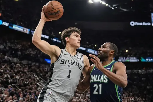 Victor Wembanyama of the San Antonio Spurs battles a Dallas Mavericks defender in the paint during an intense NBA game action shot